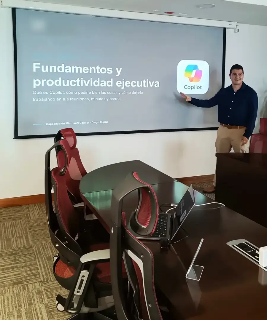Diego Cordero presenta la sesión de fundamentos de Microsoft Copilot frente a la mesa de una sala de juntas