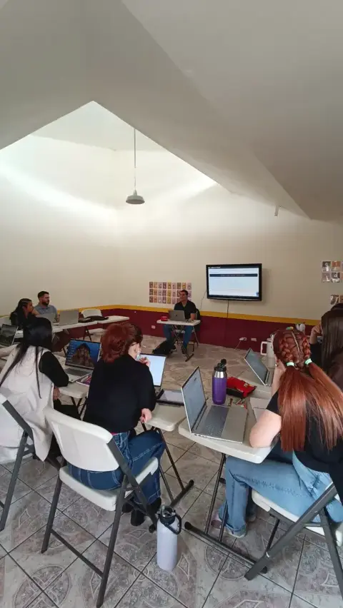 Participantes trabajan con sus laptops durante un taller práctico de inteligencia artificial